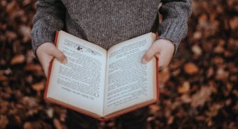 Child in a jumper holding a book